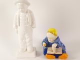 a figurine of a man reading a book next to a figurine of a man reading a book