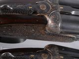 a pair of double - barrel shotguns with engraved engraving on the sides