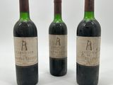 trois bouteilles de vin posées les unes à côté des autres sur une surface blanche