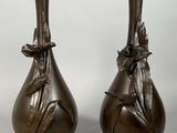 paire de vases en bronze ornés de feuilles sur fond blanc