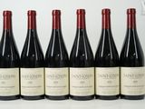 six bottles of wine are lined up on a table