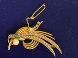 une broche en or ornée d'un oiseau et de perles