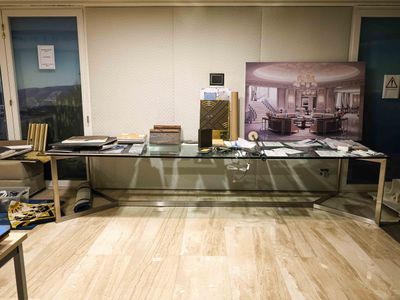 a desk with a glass top and a picture on the wall