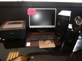 un bureau sur lequel se trouvent un ordinateur, une imprimante, une souris et d'autres objets