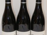 trois bouteilles de vin posées sur une table, l'une à côté de l'autre