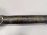a close up of a pen on a table with a white background