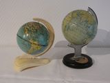 deux petits globes posés sur un socle, sur une table