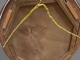 a person holding a wooden box with a yellow string around it