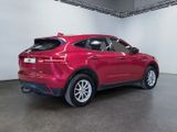 the rear end of a red car parked in a garage