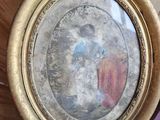 une personne tenant une photo de Jésus dans un cadre doré