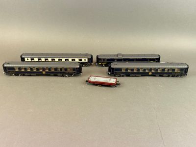 trois trains miniatures assis l'un à côté de l'autre sur une table