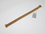 Gros plan sur un bracelet en or portant une étiquette