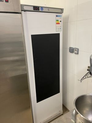un évier en inox et un réfrigérateur blanc dans une cuisine