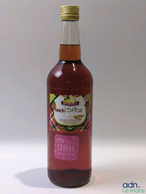 la bouteille, remplie de jus de fruits, repose sur une surface blanche