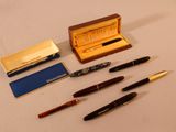 beaucoup de stylos et un étui à stylos sur la table