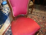 une photo d'une chaise rouge posée sur un tapis dans une pièce
