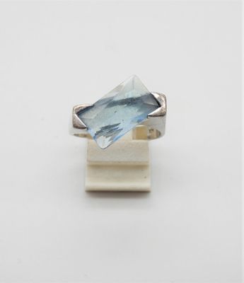 un gros plan d'une bague sertie d'une topaze bleue