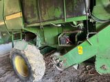 a green tractor that is parked in the dirt