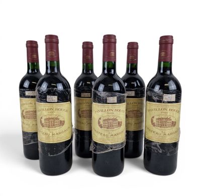 four bottles of wine are lined up on a white surface