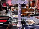 une statue de Jésus sur une croix dans une pièce remplie d'autres objets