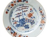 a blue and white plate with an orange and blue design on it