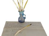 un vase bleu rempli de crayons posé sur une feuille de papier