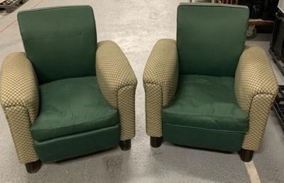 une paire de fauteuils club rembourrés verts dans un magasin