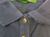 the back of a blue polo shirt with a green label on it