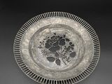 un plat ancien en argent orné de fleurs et de feuilles