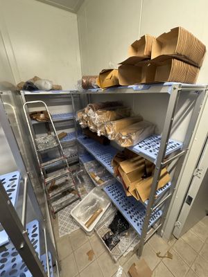 une étagère métallique sur laquelle sont posées des boîtes, dans une pièce