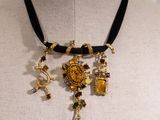 gold and black necklace with charms and charms on a mannequin