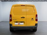 the rear end of a yellow van parked inside of a building