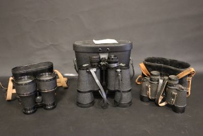three binoculars and a case are sitting on a table