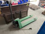 a green pallet sitting on the floor in a garage