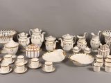a lot of white and gold china on display
