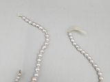 a white pearl necklace with a silver clasp on a white table