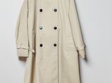 une photo d'un trench-coat beige suspendu à un cintre