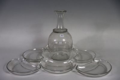 a glass vase and six glasses on a white table