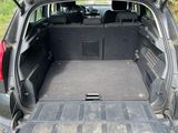the back of a car with its trunk open on the side of the road