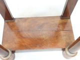 a small wooden table with two metal legs on it