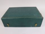 an old green suitcase sitting on top of a white table