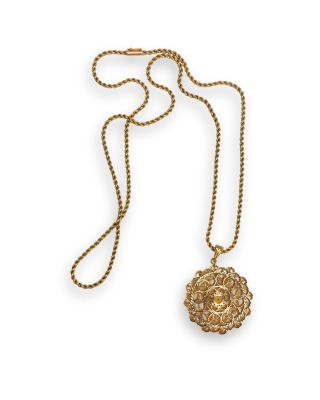 a gold necklace with a lion head on a chain