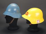 pair of yellow and blue hard hats sitting on top of a black mannequin head