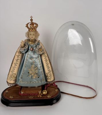 une figurine représentant une femme en robe bleue, placée sous un dôme en verre