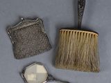 a brush, mirror, and purse sitting on a table