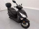 un scooter noir garé dans une pièce blanche