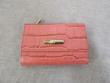 an image of a pink wallet with a gold clasp on it