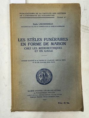 un vieux livre posé sur une table à côté d'un mur blanc