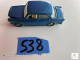une petite voiture bleue sur laquelle figure un numéro, à côté d'un bout de papier bleu
