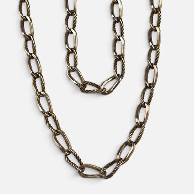 a necklace and bracelet set with a long chain on a white background